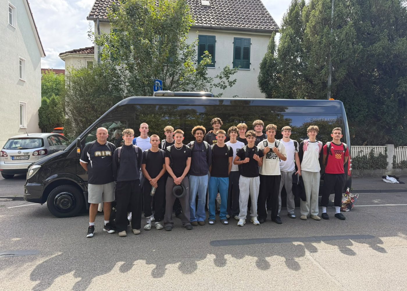 Die U18 der VfL Kirchheim Knights mit Trainer vor dem Bus bei der Abfahrt nach Köln